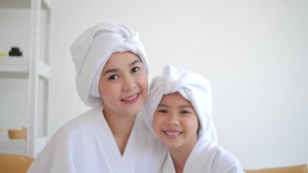 シャワーの後に頭にタオルを被ってカメラを見るアジア系の母親と娘の笑顔 入浴コンセプト — ストック動画