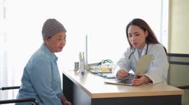 Asyalı kadın doktor ve klinikte konuşan yaşlı kadın hasta. Tıbbi ve sağlık hizmetleri, danışmanlık ve terapi kavramı.