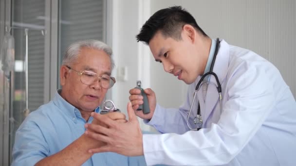 Asijský Lékař Ukazující Jak Cvičit Ruční Rukojetí Staršímu Pacientovi Lůžku — Stock video