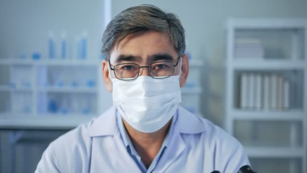 Portret Starszego Azjatyckiego Lekarza Noszącego Sterylną Maskę Patrzącego Kamerę Laboratorium — Wideo stockowe