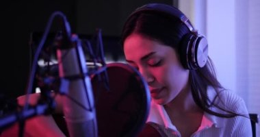 Kadın şarkıcı akustik gitar çalıyor ve şarkı söylüyor. Kayıt stüdyosunda şarkı söyleyen Asyalı bir kadın. Albümü için kayıt yapıyor..