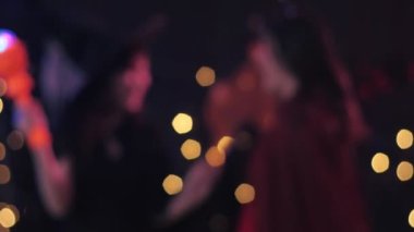 Cadılar Bayramı kostümlü kadınların dans etmesi ve ev partisinin arka planında eğlenmesi. Cadılar Bayramı 'nın aydınlık bokeh partisi.