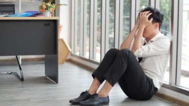 Öfkeli Asyalı işadamı ofisteki çalışma masasının yanına oturur, işini kaybeder, depresyondaki işsizdir. İşsizlik Kurumu.