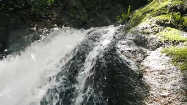 Tropikal nehirde nehir ya da göl şelalesinin yavaş akışı çok doğal. Vahşi dağ nehri berrak akarsu. Taş kayaların aktığı gevezelik eden bir dere..