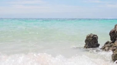 Plaj tropikal kumlu ve kaya kıyısı arka planı. Tasarım için kopyalama alanı olan güzel bir yaz tatili.