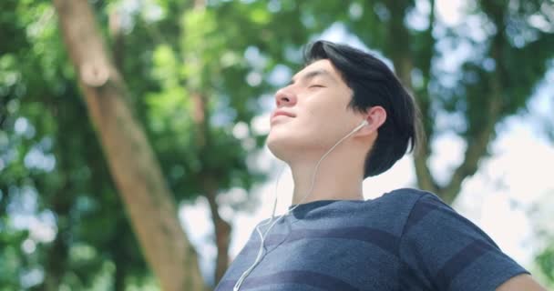 Handsome Asian Man Relaxing Eyes Closed Wearing Headphones Listening Music — Stockvideo
