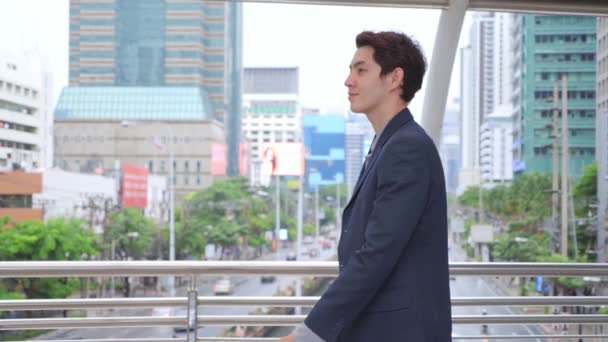 都市の背景に屋外を歩くアジアの混合レースビジネスマン 若いマネージャー 中小企業のビジネスマン エグゼクティブ 新世代 男性の成功コンセプト — ストック動画