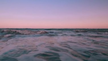 Akşamları deniz dalgaları kumsala vurur. Güzel, yumuşak, alacakaranlık gökyüzü.