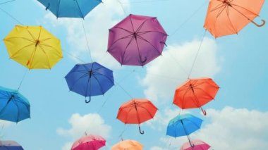 Renkli şemsiyeler gökyüzünde asılı