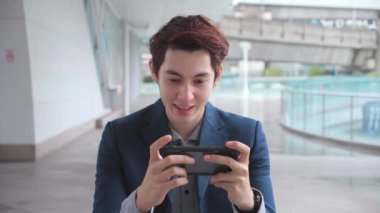 Genç işadamı telefonda oyun oynamaktan hoşlanıyor..