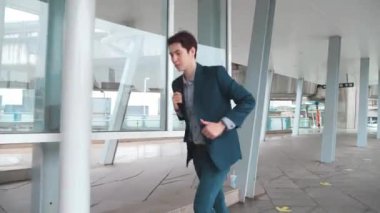 Genç işadamı koşar ve saatine bakar. Kendine güvenen adam buluşmaya ve işe geç kalır. Takım elbiseli bir adam modern binanın yakınında koşuyor. Randevu için acele eden yakışıklı adam..