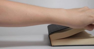 Elle açılan bir kitap. Eller beyaz arkaplan üzerine boş bir kitap açıyor.