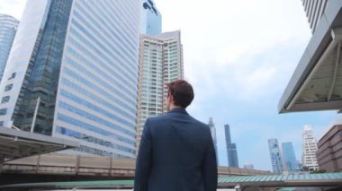 Düşünceli bir iş adamının modern Office Building 'in arka planında dikilirken dışarı baktığı arka plan. 4K Yavaş Hareket Şirketi.