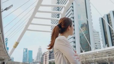 Modern ofis binasının yanında duran iş kadını dışarı bakıyor. 4K Yavaş Hareket Kurumsal Çekim 360 civarında Kamera ile