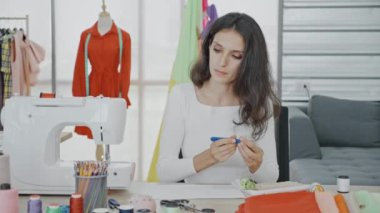 Moda tasarımcısı kadın modern stüdyoda tasarım projesinde çalışıyor..