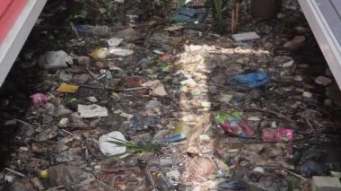 Çöp ve diğer döküntüler suyun üzerinde yüzüyor. Deniz kirliliği. Sudaki plastik atıklar, vahşi yaşamı öldürüyor..