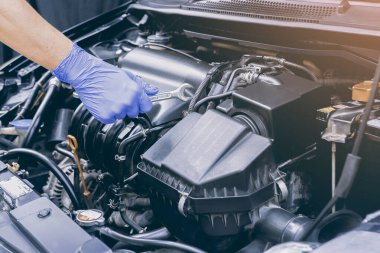 Otomobil tamircisi elleri müşteriden önce bir otomotiv motoru tamir ediyor. Güvenlik denetim motoru. Tamirat servisi. Araba motoru konsepti.,