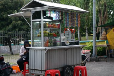 Gresik, Doğu Java, Endonezya - 12 Mart 2022: Gresik City 'deki Maulana Büyük Camii önünde kese içeceği ve meyve suyu satıcısı                                    