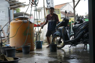 Lamongan, Endonezya - 27 Mart 2022: Motosikletini bir oto yıkama dükkanında yıka