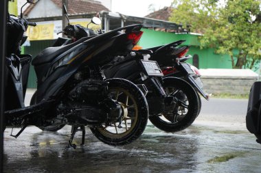 Lamongan, Endonezya - 27 Mart 2022: Motosikletini bir oto yıkama dükkanında yıka