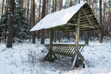 Wooden pasture for wild animals in the middle of the forest in winter time. 