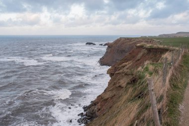 Dalgalar ve dalgalar kayalıklara çarpıyor.