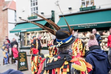 Whitby, Kuzey Yorkshire, Birleşik Krallık - 03 Mart 2022: Sülün tüyleri ve Ukrayna bayrağının renkleri olan şapkalı bir adam. Ukraynalı mülteciler için bağış toplama kampanyası.