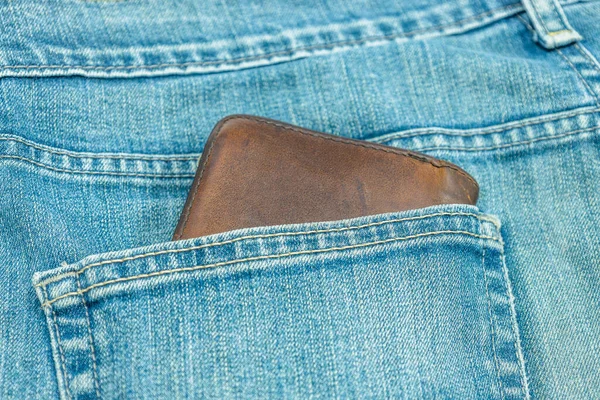 Денежный бумажник в заднем кармане синих джинсов — стоковое фото