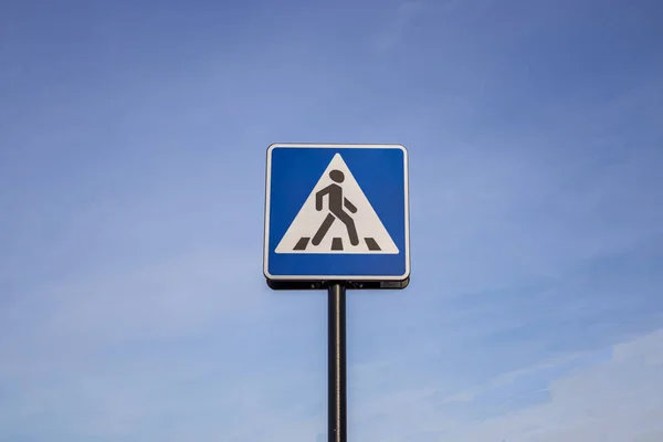 Blauw-witte voetgangers kruising teken op de lucht achtergrond — Stockfoto
