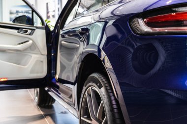 Mavi Porsche Macan arabasının arka sol görüşü