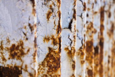 Korozyon, pas, derin çatlaklar ve dökülmüş boya desenli metal köprü..