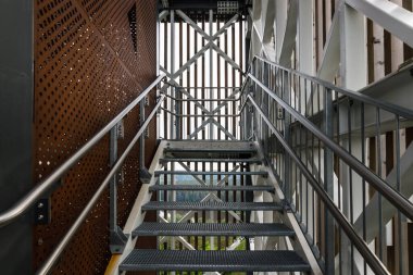 Demir merdiveni ve paslanmaz çelik tırabzanı olan çelik yapı..