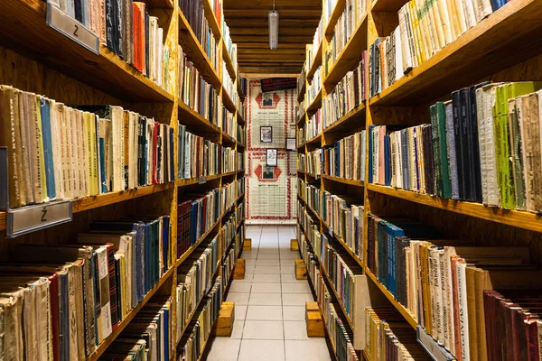 Kütüphanedeki ahşap bir rafta eski moda kitaplar..