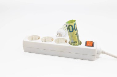 Euro banknotları elektrik prizine sıkışmış. Artan elektrik fiyatları kavramı.