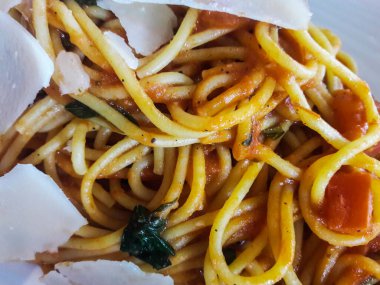 Domatesli spagetti, parmesan ve fesleğen. İtalyan yemeği..