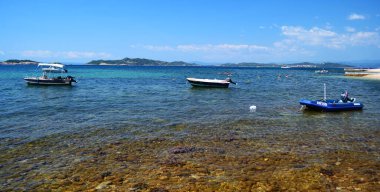 URANOPOLIS, HALKIDIKI, GREECE - 24 AĞUSTOS 2017: Plaja yakın açık deniz suyundaki küçük tekneler.