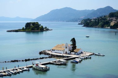 Pontikonisi manastırı ve Vlachernon kilisesi yaya köprüsü ile birbirine bağlı olan Fare adasının panoramik manzarası. Korfu, Yunanistan.