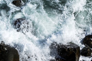 Deniz dalgaları kayalıklara ve deniz köpüğüne çarpıyor. Karadeniz, Köstence, Romanya.