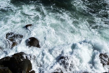 Deniz dalgaları kayalıklara ve deniz köpüğüne çarpıyor. Karadeniz, Köstence, Romanya.