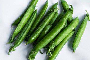 İzole edilmiş beyaz arkaplanda bezelye kabukları.