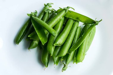 İzole edilmiş beyaz bir arkaplanda bezelye kabuğu yığını.