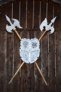 Sırtında halberd olan bir kalkan. Hunedoara 'da Corvin' in kalesinin yanındaki bir kapının üstünde.