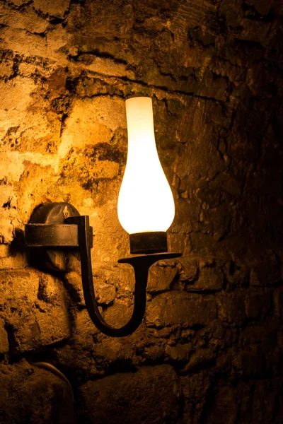 Karanlık bir odada, duvarda asılı duran lamba..