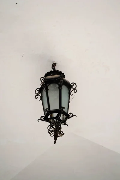 一只黑色的老灯笼挂在白色的冰壶上 — 图库照片