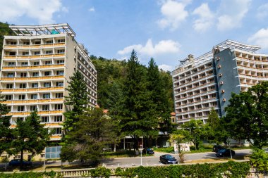 BAILE HERCULANE, ROMANIA-SEPTEMBER 09.2019: Cerna Nehri 'nin her iki tarafındaki Baile Herculane tatil beldesi, Akdeniz' in altı etkileri ve mineral suları ile birlikte, intramontane depresyon iklimine sahiptir..