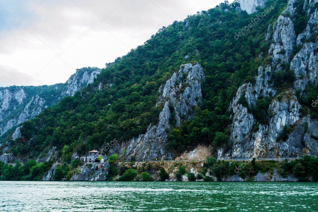 The water foam in the back of a boat, mountains, Mraconia monastery and the Danube river, Cazanele Dunarii, Romania.