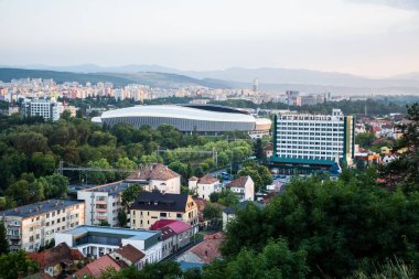 CLUJ, ROMANIA - 28 Temmuz 2021: Cluj Arena stadyumu, Central Park ve Grand Hotel Napoca ile şehir üzerinde hava manzarası.