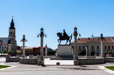 ORADEA, ROMANIA - 30 Temmuz 2021: 1. Ferdinand heykeli ve Ay Kilisesi ile Birlik Meydanı.