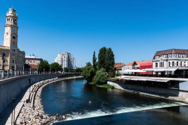 ORADEA, ROMANIA - 30 Temmuz 2021: Cris Nehri (Crisul Repede) ve Oradea belediye binası. Romanya