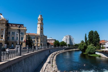 ORADEA, ROMANIA - 30 Temmuz 2021: Cris Nehri (Crisul Repede) ve Oradea belediye binası. Romanya